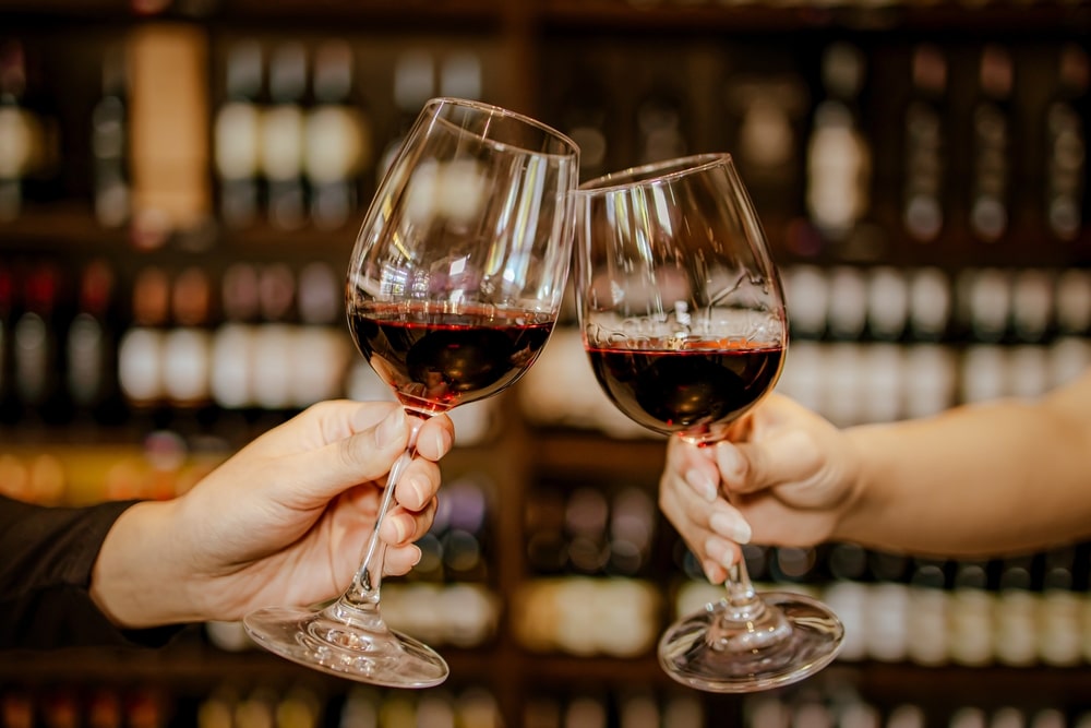 Couple with two red wine glasses in a tasting room during romantic getaways in Georgia