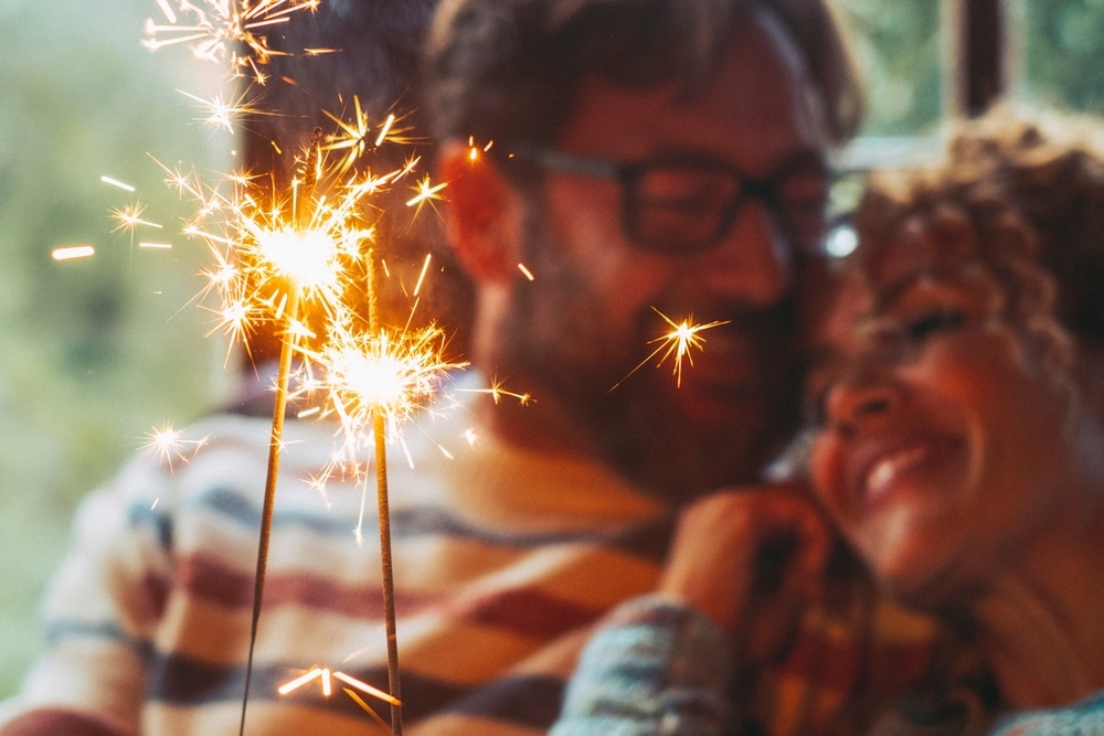 Couple lighting sparklers and enjoy a romantic moment during their romantic getaways in North Georgia