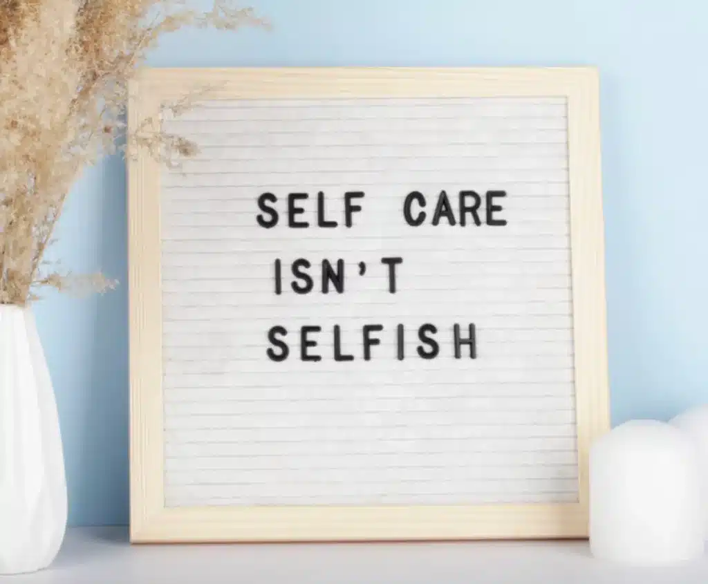 A Wellness Retreat in the North Georgia Mountains That Changes Everything 5 Letter board reading Self Care Isnt Selfish beside dried pampas grass and a candle